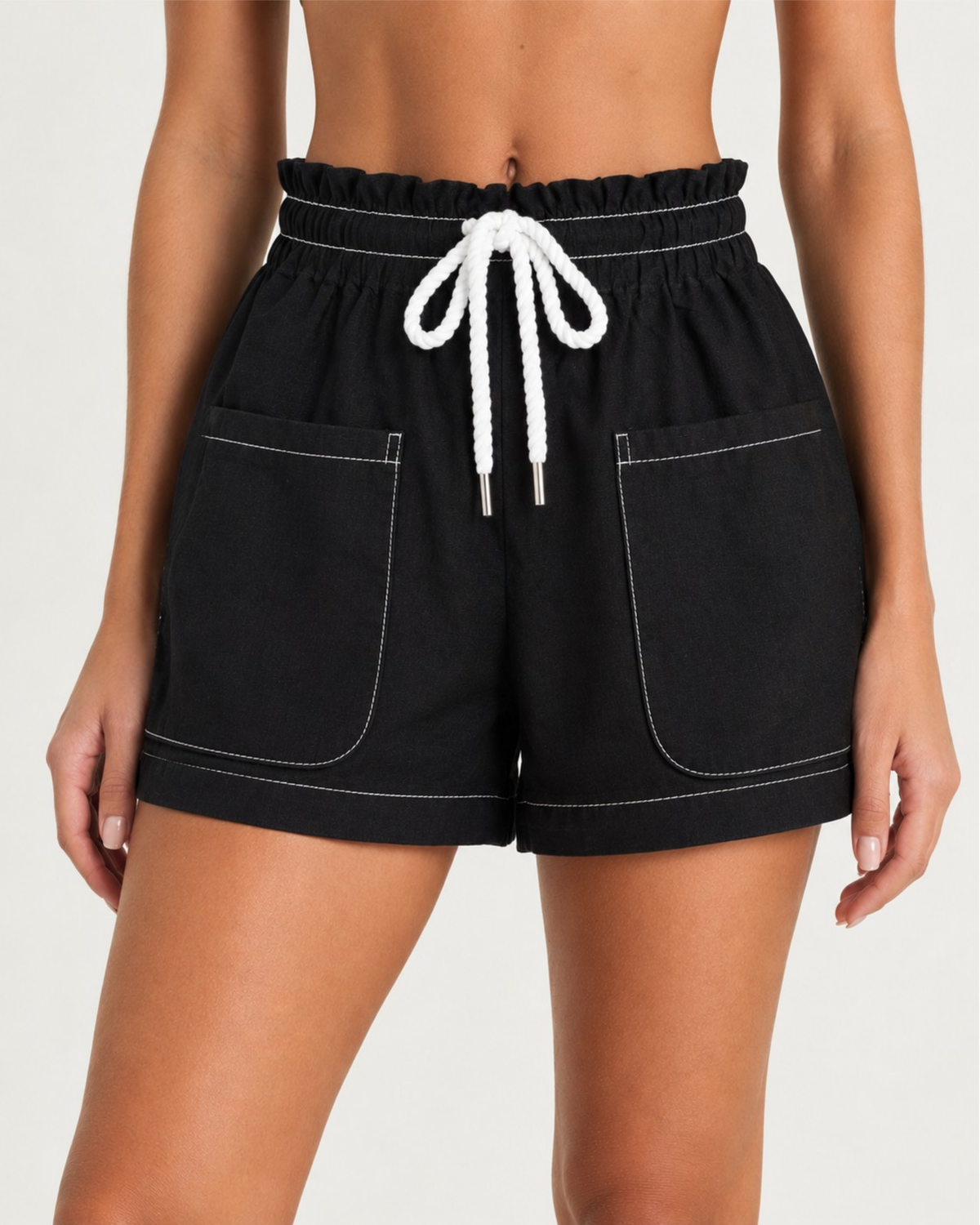 Black high-waisted shorts with a white drawstring and white contrast stitching, shown on a model from the back.